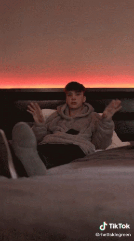 A Tiktok Video Of A Person Laying On A Bed With Their Head Down GIF