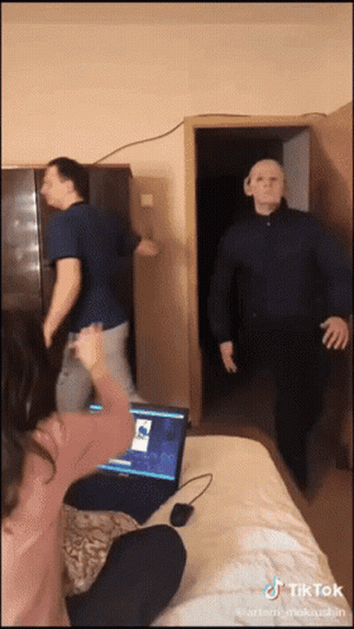 A Tiktok Video Shows A Man Wearing A Mask And A Woman Sitting In Front Of A Laptop GIF