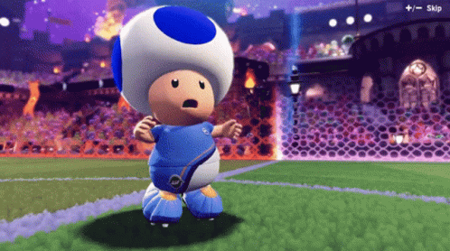 A Toad In A Blue And White Soccer Uniform Is Standing On A Soccer Field GIF