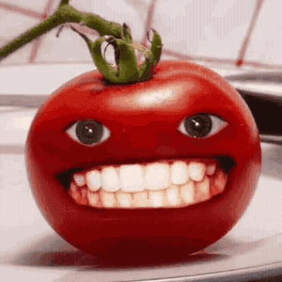 A Tomato With A Big Smile On It 'S Face Is Sitting On A Plate . GIF