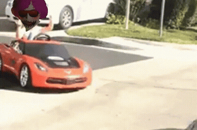 A Toy Car Is Driving Down A Street With A Person Driving It . GIF