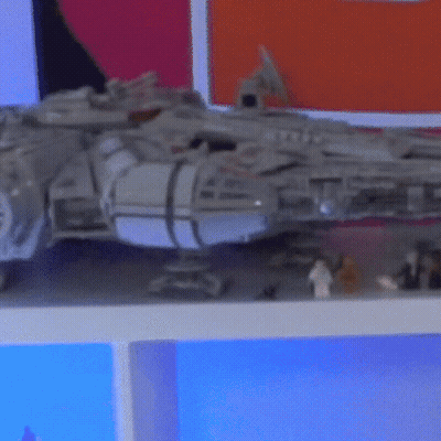 A Toy Falcon Sits On A Shelf Next To A Few Lego Figures GIF