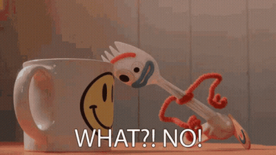 A Toy Fork Is Standing Next To A Coffee Mug With A Smiley Face On It GIF
