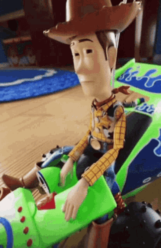 A Toy Story Woody Doll Is Sitting In A Toy Car . GIF