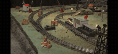 A Toy Train Set With Barrels And A Building With The Number 1 GIF