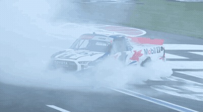 A Toyota Truck Is Driving Down A Race Track With Smoke Coming Out Of It GIF