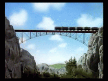 A Train Going Over A Bridge With A Blue Sky In The Background GIF