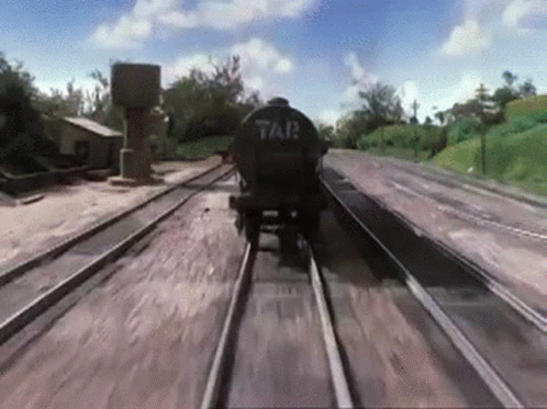 A Train Is Going Down The Tracks With A Tank On The Back That Says Tar GIF