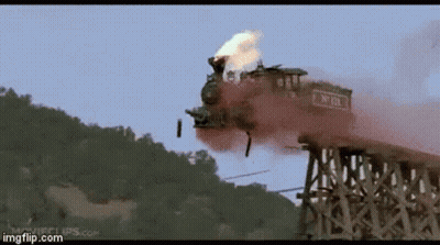 A Train Is Going Over A Wooden Bridge With Smoke Coming Out Of It GIF