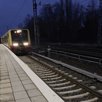 A Train Is Pulling Into A Station With A Sign That Says H GIF