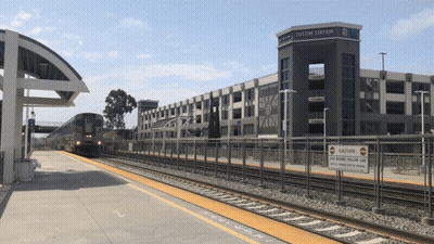A Train Station With A Sign That Says " Caution " On It GIF