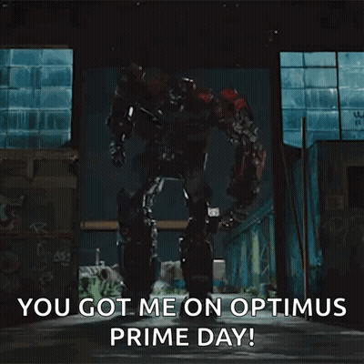 A Transformer Robot Is Standing In A Dark Room And Says `` You Got Me On Optimus Prime Day ! '' GIF