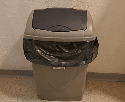 A Trash Can With A Black Bag In It And A Label That Says ' Recycling ' GIF