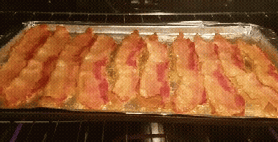 A Tray Of Bacon Is Sitting In An Oven GIF