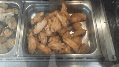A Tray Of Fried Chicken Wings Sits On A Counter GIF