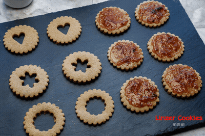 A Tray Of Linzer Cookies Sits On A Black Surface GIF