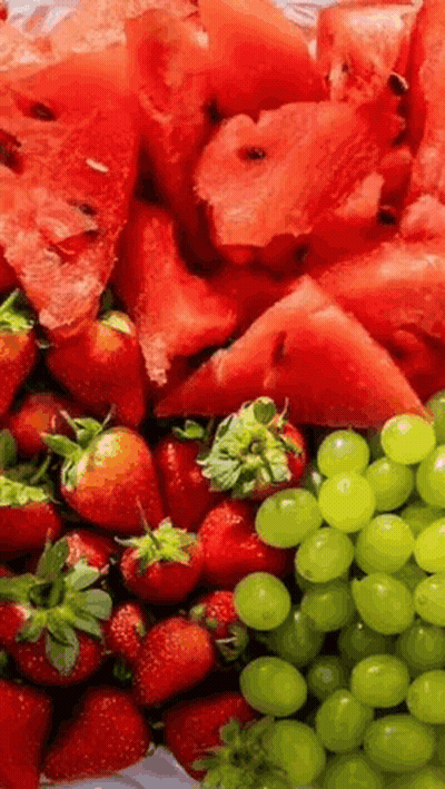 A Tray Of Watermelon , Strawberries , And Grapes . GIF