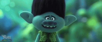 A Troll From The Trolls World Tour Is Smiling And Looking At The Camera GIF