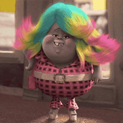A Troll With A Rainbow Colored Wig Is Wearing A Pink Plaid Outfit GIF