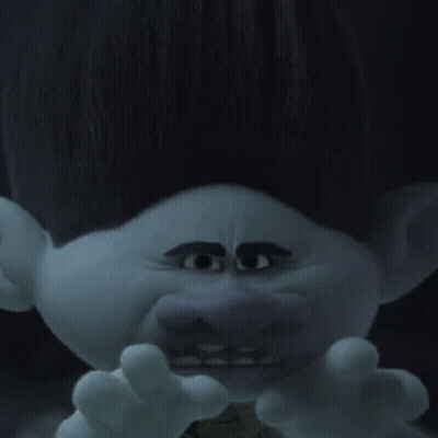 A Troll With Big Eyes And A Mustache Is Wearing A Green Vest . GIF