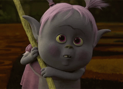 A Troll With Pink Hair Is Holding A Stick And Making A Funny Face GIF