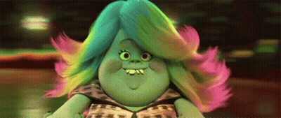 A Troll With Rainbow Hair Is Smiling And Wearing A Leopard Print Dress . GIF