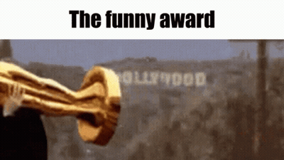 A Trophy Is Being Held In Front Of A Sign That Says Hollywood GIF