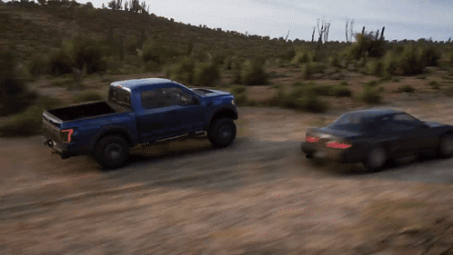 A Truck And A Car Are Driving Down A Dirt Road GIF