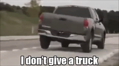 A Truck Is Driving Down A Road With The Words `` I Don T Give A Truck '' Written On It . GIF