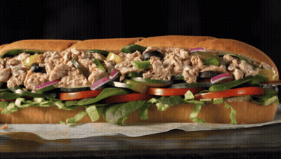 A Tuna Sandwich With Lettuce Tomatoes And Olives On A Bun GIF
