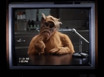 A Tv Screen Shows Alf Talking Into A Microphone GIF