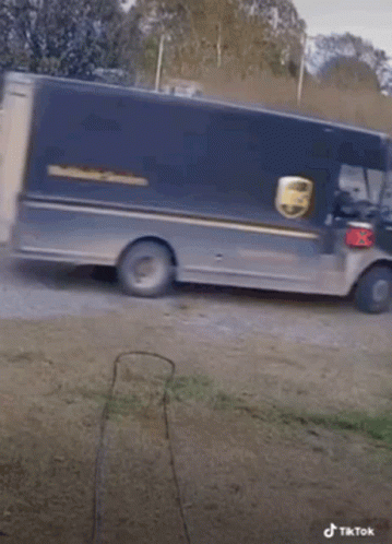 A Ups Truck Is Pulling A Trailer With Dogs Behind It GIF