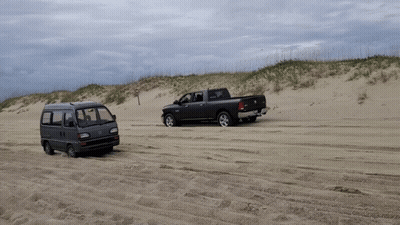A Van And A Truck Are Parked In The Sand GIF