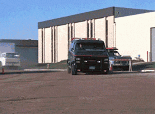 A Van With A License Plate That Says ' Gmc ' On It Is Parked In Front Of A Building GIF