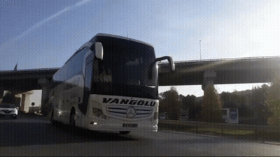 A Vanyolu Bus Is Driving Down A Highway Under A Bridge GIF