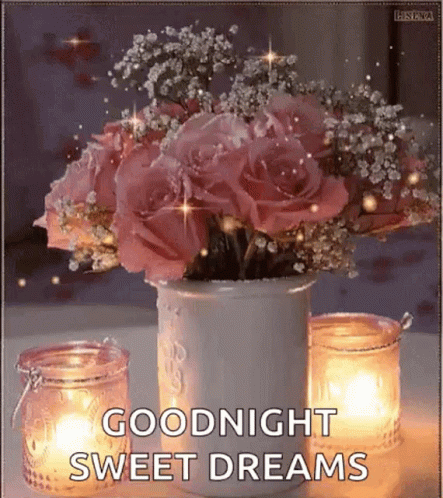 A Vase Filled With Pink Roses And Baby 'S Breath Next To Candles . GIF