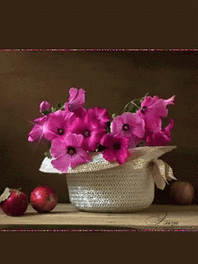 A Vase Of Pink Flowers Sits On A Table With Apples GIF