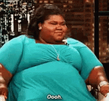 A Very Fat Woman In A Blue Shirt Is Sitting On A Chair . GIF