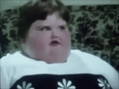 A Very Fat Woman Is Sitting In A Chair And Making A Face . GIF