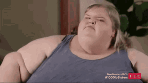 A Very Fat Woman Is Sitting On A Couch . GIF