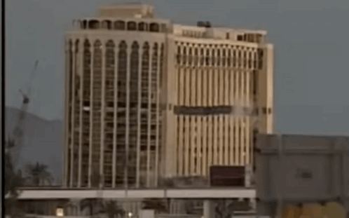 A Very Tall Building With A Lot Of Windows And A Bridge In The Background GIF