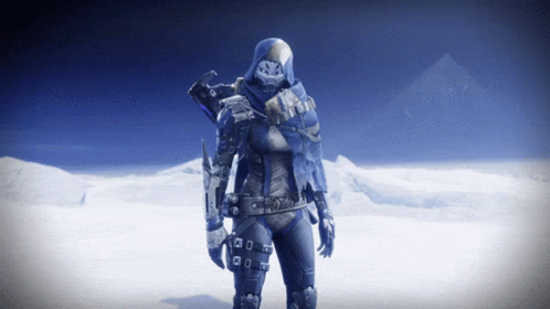 A Video Game Character With A Hood On Stands In Front Of Snowy Mountains GIF