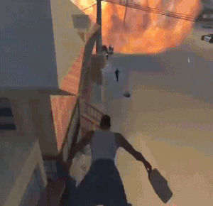 A Video Game Scene With A Man Holding A Gun In Front Of A Fire GIF