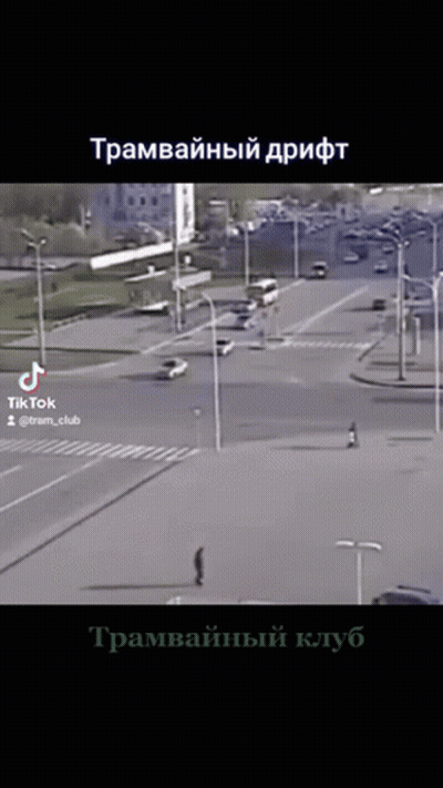 A Video Of A Man Walking Down A Street In A City With Russian Writing On The Bottom GIF