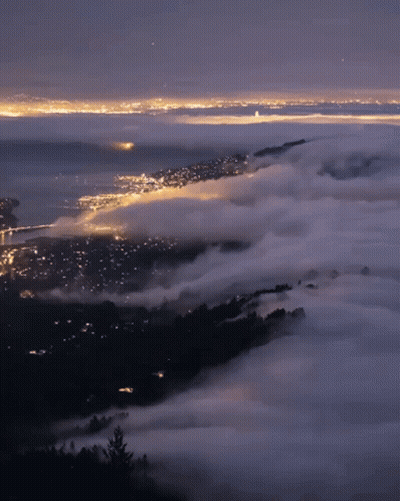 A View Of A City At Night With A Lot Of Clouds GIF