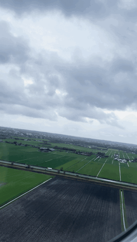 A View Of A Cloudy Sky Over A Lush Green Field GIF