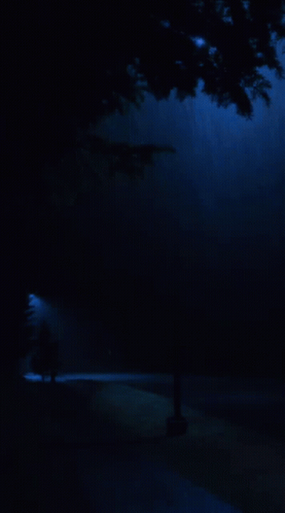A View Of A Mountain Range From A Window With A Blue Sky GIF