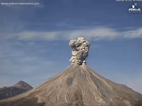 A Volcano Is Erupting With A Huge Cloud Of Smoke Coming Out Of It GIF