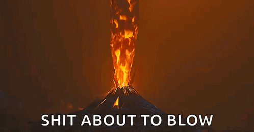 A Volcano Is Erupting With A Lot Of Fire Coming Out Of It And The Words `` Shit About To Blow '' Below It . GIF