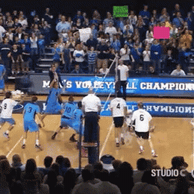 A Volleyball Game Is Being Played In Front Of A Crowd With A Sign That Says M 'S Volleyball Champion GIF